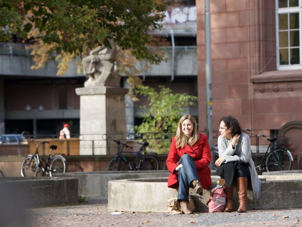 Zwei Studierende auf Campus unterhalten sich