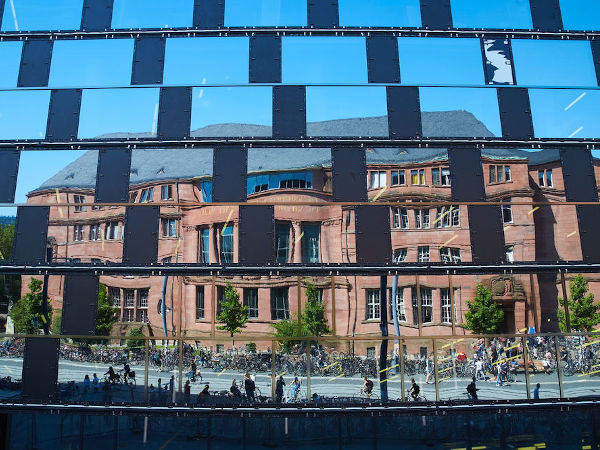 Das KG I gespiegelt in der Fassade der UB Freiburg