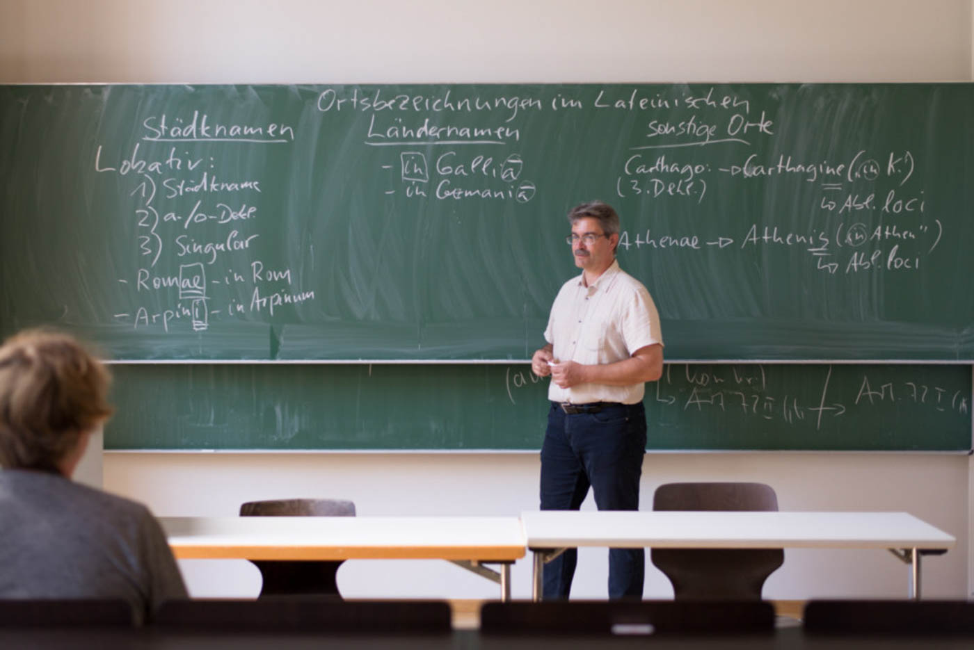 Herr Faller erkärt etwas einem Studenten in der ersten Sitzreihe