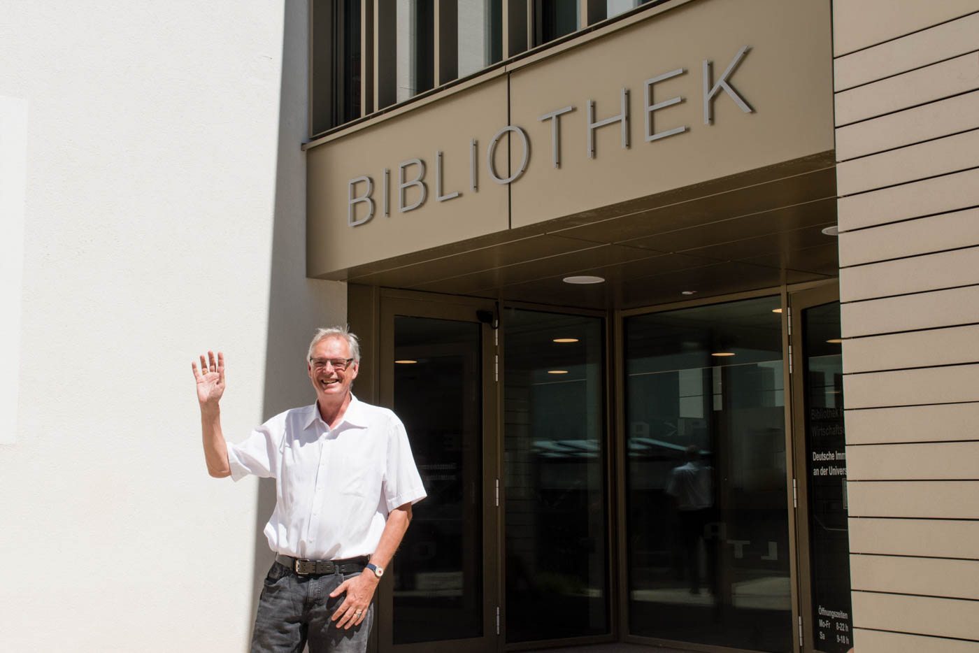 Herr Neumärker winkt vor Bibliothek