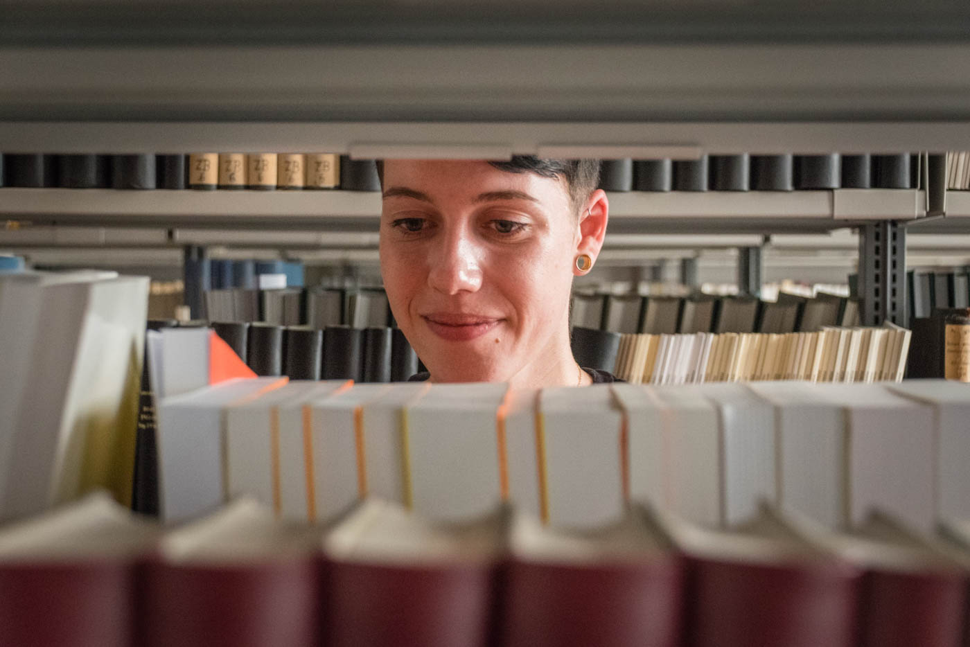 Samira sucht etwas im Bücherregal