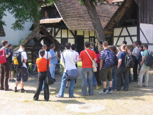 Gruppe von Studierenden lauscht einem Vortrag vor einem Schwarzwaldhaus