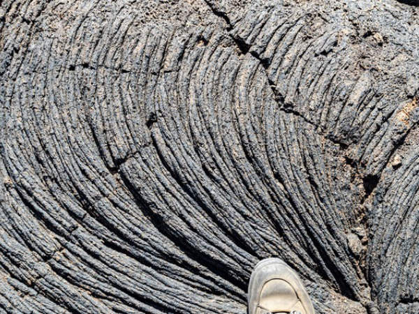 Mit einem halben Fuß auf Pahoehoe-Lava (El Hierro, Kanarische Inseln, Spanien).