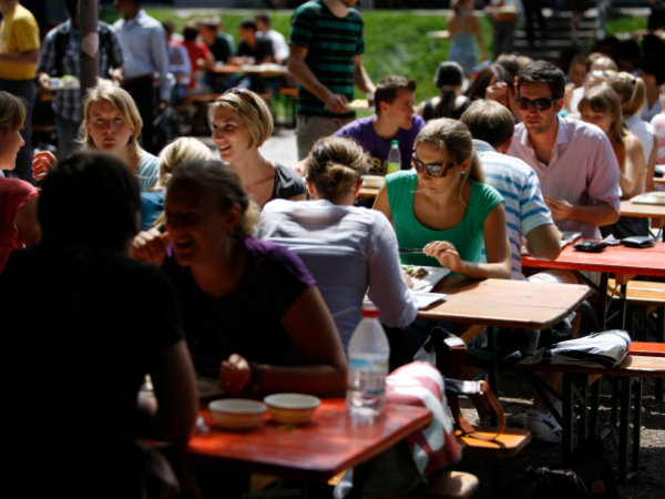 Studierende in der Mittagspause auf dem Außenbereich der Mensa der Universität.