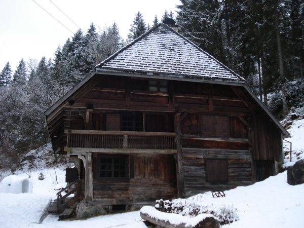 Schwarzwaldbauernhaus in Schneelandschaft.