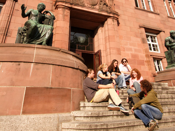 Eine Gruppe Studierende auf den Treppen vor der Universität Freiburg sitzend