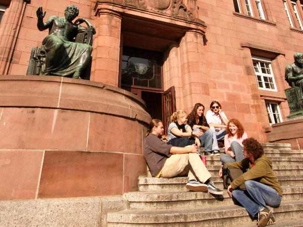 Eine Gruppe Studierende auf den Treppen vor der Universität Freiburg sitzend